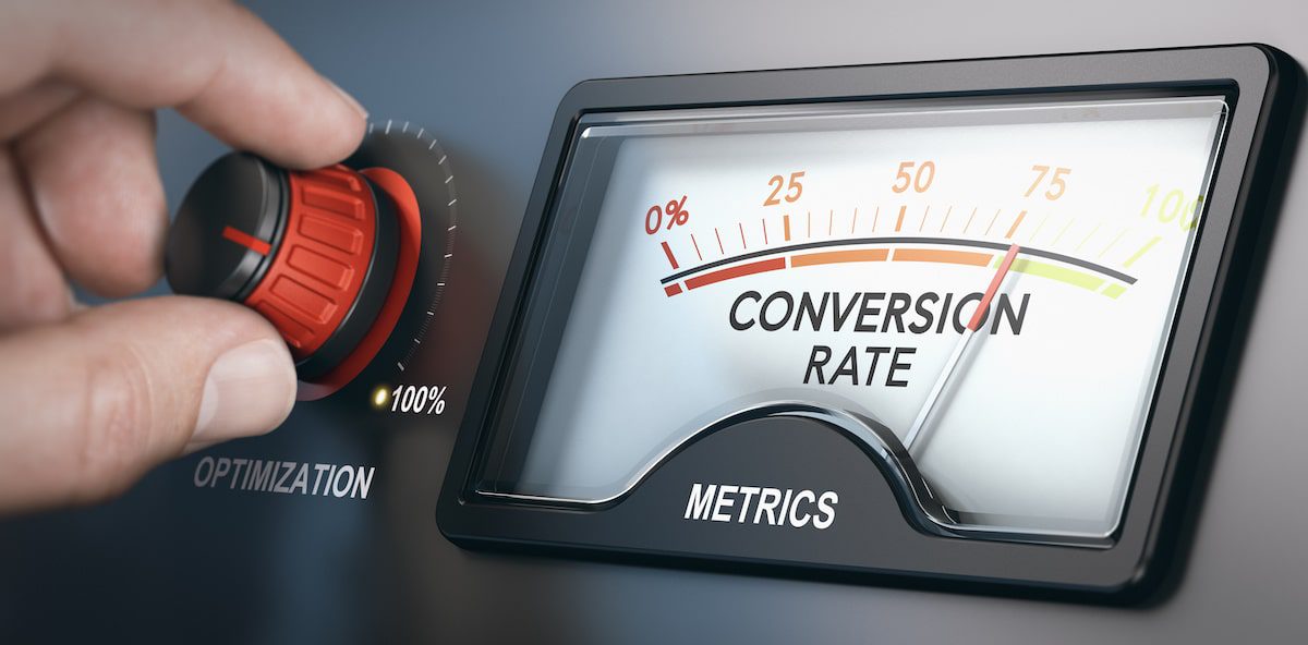 hand turns up dial that says "conversion" next to a meter that says "metrics"