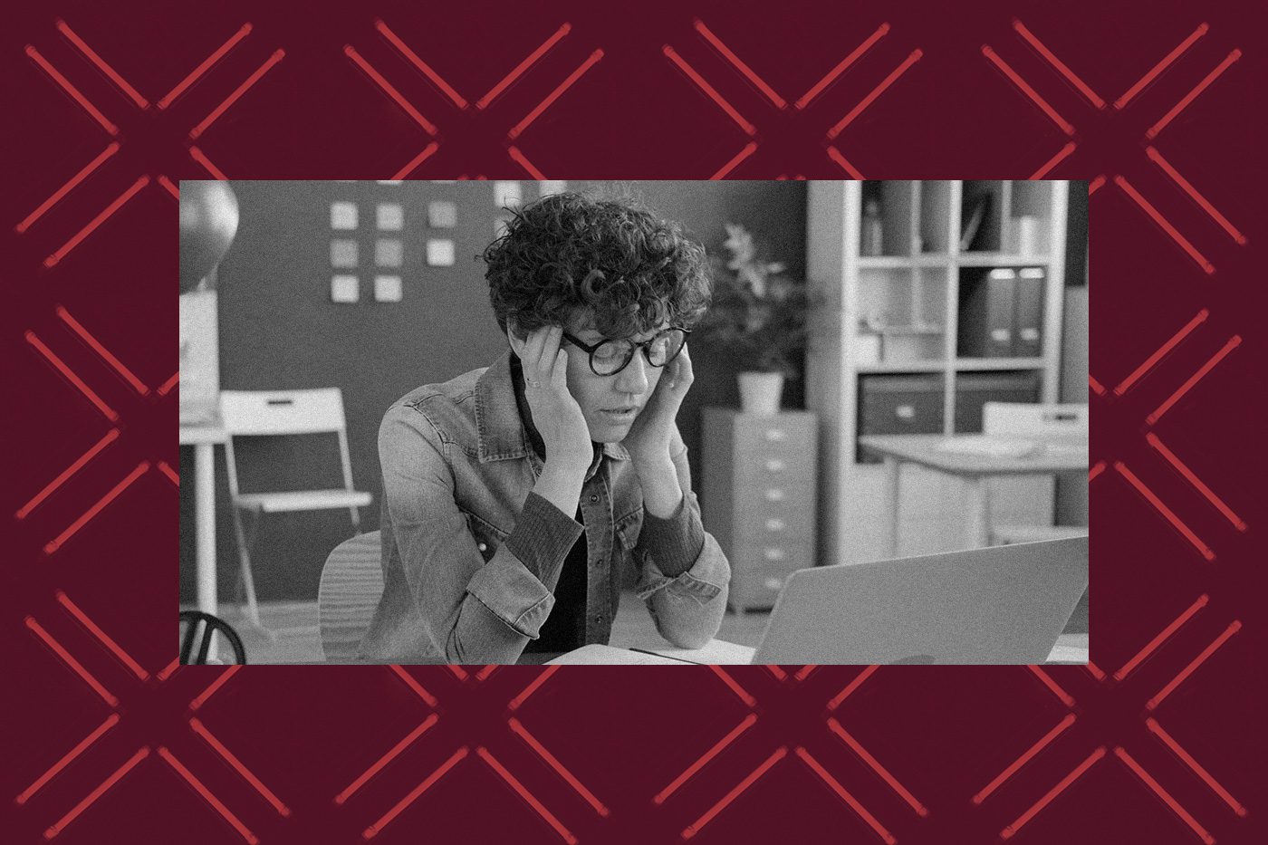 A nonprofit professional looks stressed while working on a laptop, representing the frustration of managing Google Ad Grant requirements and avoiding account suspension.